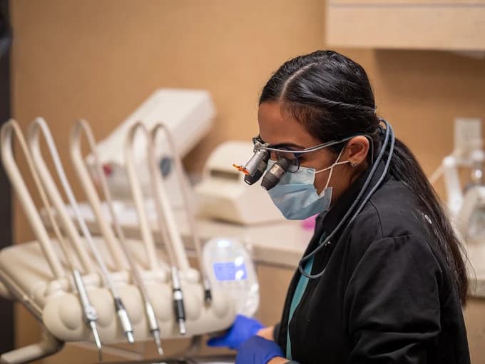 All Smiles Dental Care dentist wearing surgical loupes during a procedure in Calgary